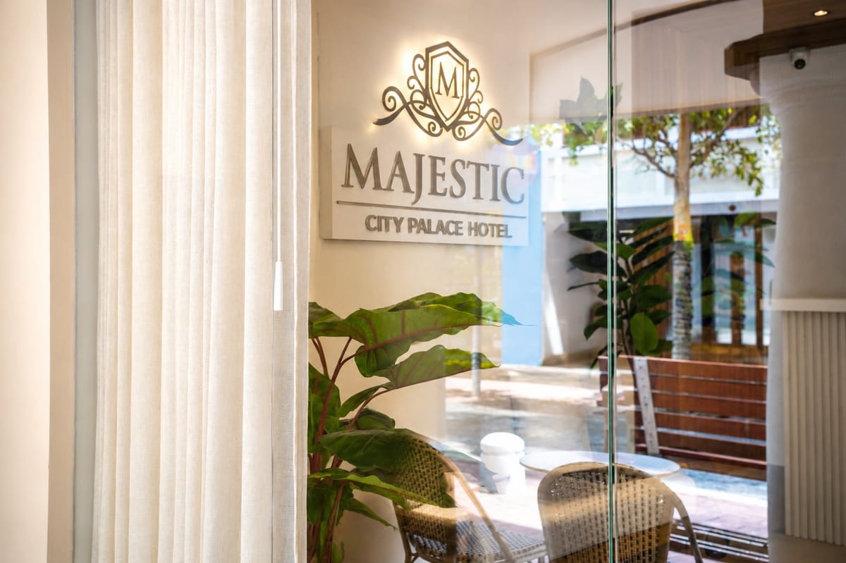 The lit Majestic City Palace sign inside the glazed front, the arcade bench on Breedestraat beyond
