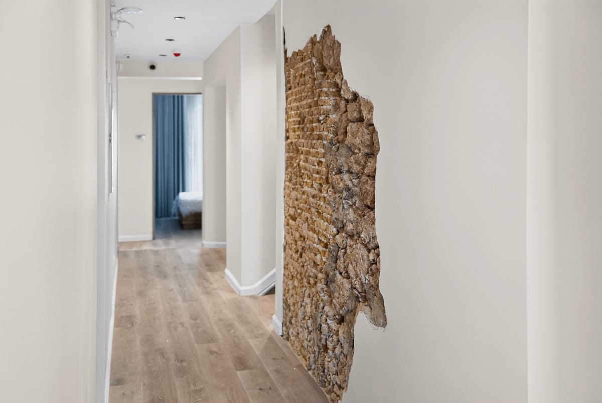A corridor inside the hotel where a panel of the original 1892 coral stone wall is left exposed