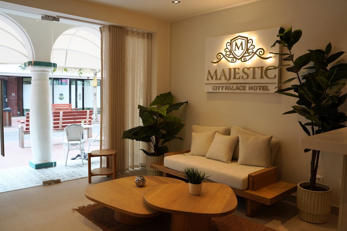 The lobby seating area of Majestic City Palace, with the crest wall behind and the arcade through the glass