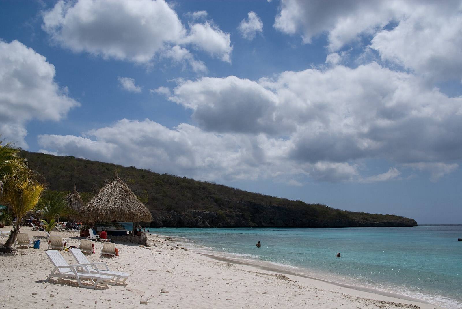 Loungers and palms along the white sand of Cas Abao beach on Curaçao, where a well-packed beach bag earns its keep