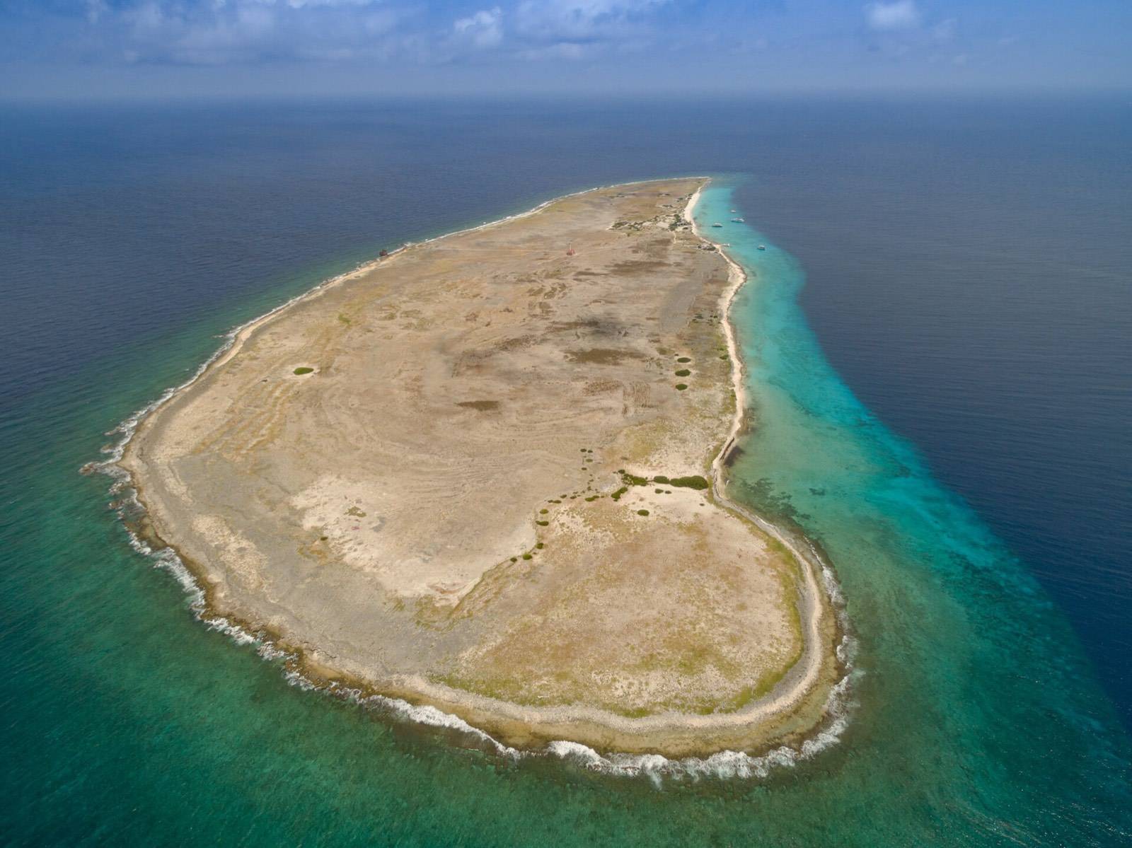 Aerial view of Klein Curaçao, a flat sandy islet ringed by turquoise water and open sea