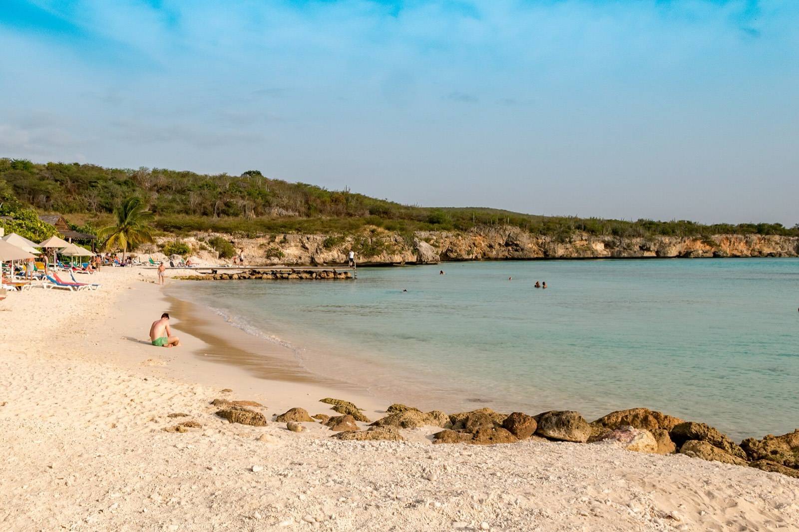 The calm, shallow turquoise water and wooden pier at Porto Mari beach, Curaçao