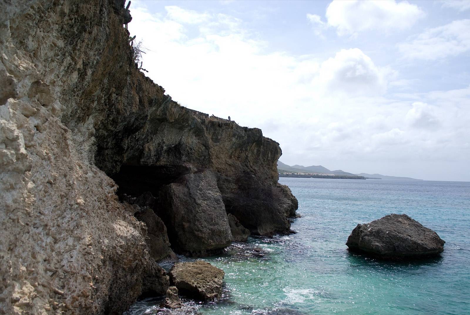 Limestone cliffs meeting turquoise water at Westpunt on the western tip of Curaçao